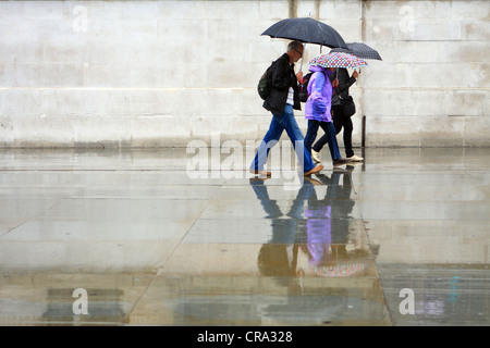 La gente ha superato una parete piana sotto la pioggia Foto Stock