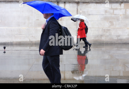 La gente ha superato una parete piana sotto la pioggia Foto Stock