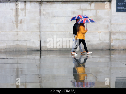 La gente ha superato una parete piana sotto la pioggia Foto Stock