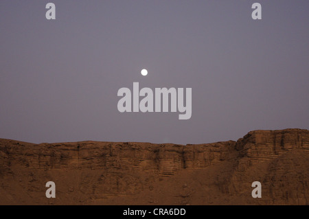 La luna in uscita su formazioni rocciose nella sabbia rossa nel deserto - Riyadh, Regno di Arabia Saudita Foto Stock