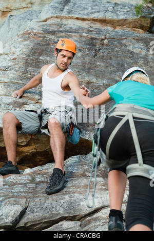 Gli alpinisti scala ripida roccia Foto Stock