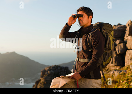 Escursionista utilizzando binocolo nel campo rocciose Foto Stock