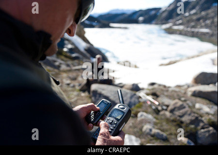 Escursioni guida utilizzando un telefono satellitare, vicino Tasiilaq o Ammassalik, est della Groenlandia, Groenlandia Foto Stock