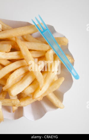 Le patatine fritte in un piatto di carta con uno snack forcella Foto Stock