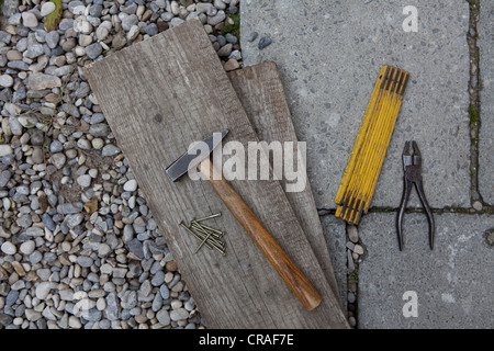 Martello, pieghevole, pinze e tavole di legno Foto Stock