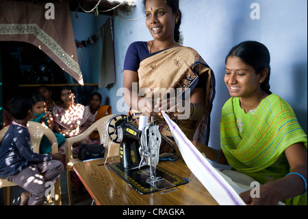 Le giovani donne sono insegnato taglio e cucito sotto la supervisione di un insegnante, la formazione professionale e la qualificazione tecnica Foto Stock