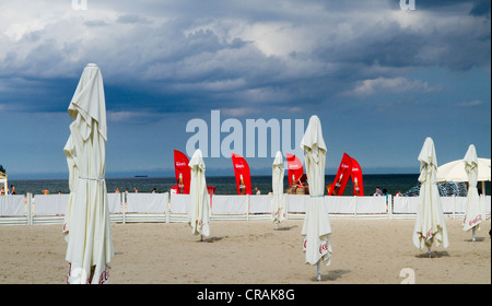 Arrotolata ombrelloni da spiaggia sotto il cielo tempestoso in Sopot Poland Foto Stock