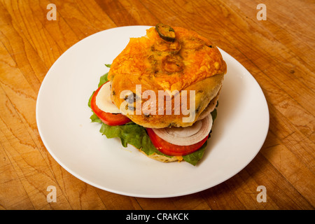 Una Turchia burger su un formaggio jalapeno bagel con pomodoro a fette di cipolla e lattuga romana. Foto Stock