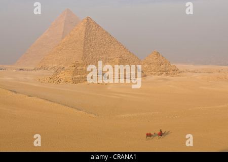 Piramidi di Giza, camel pilota davanti, Egitto, Africa Foto Stock