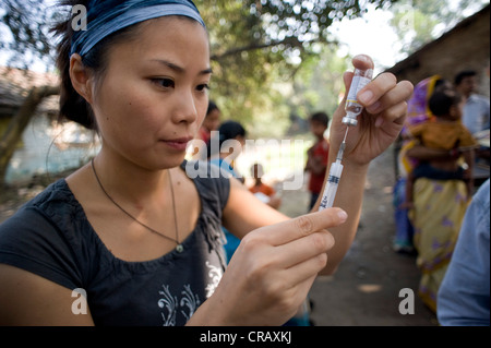 Dipendente del tedesco di medici per i Paesi in via di sviluppo la preparazione di una siringa in una campagna di vaccinazione a Calcutta, , India Foto Stock