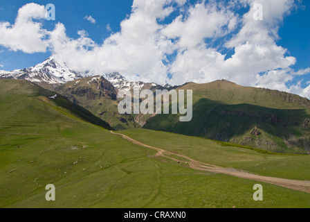 Vista dal famoso Gergeti Trinity Church o Tsminda Sameba presso il confine ceceno, Stepantsminda, Georgia, nel Caucaso Foto Stock