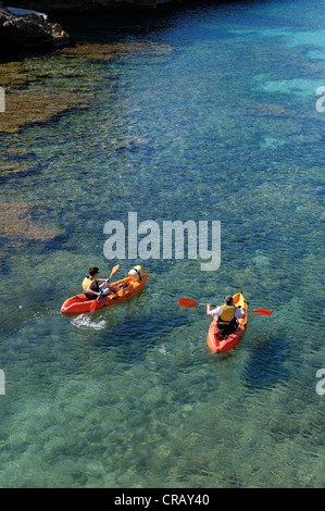 Padre e figlio kayak nelle acque cristalline di Cala Santa Galdana Minorca spagna isole baleari Foto Stock