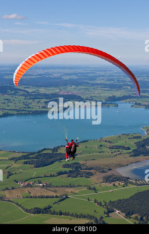 Parapendio in tandem che si affaccia sul lago Froggensee, Tegelberg Mountain, Alta Baviera, Baviera, Germania, Europa PublicGround Foto Stock