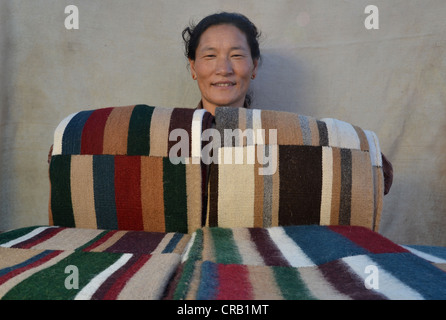 Yak tibetani tessitore di lana con orgoglio presenta la sua mercanzia, colorata lana di yak mosaico, yak coperte, copriletti, Tibet, Cina Foto Stock