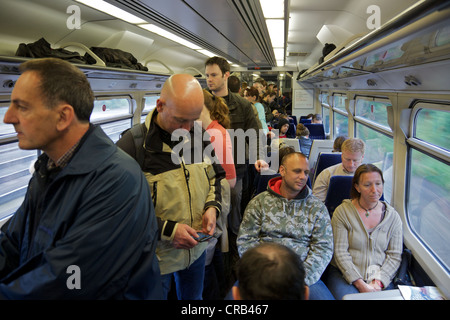 Un affollato treno dei pendolari sul modo di Londra, Inghilterra Foto Stock