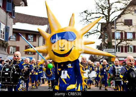 Grande tamburo di un gruppo Guggen, carnevale marching band, vestito come il sole, 35th Motteri parade di Malters, Lucerna Foto Stock