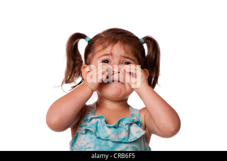 Triste pianto infelice carino piccolo giovane ragazza toddler tergi lacrime, isolata. Foto Stock