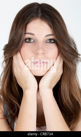 Giovane donna con la testa con le mani, ritratto Foto Stock