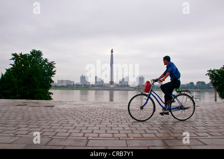 Ciclista nella parte anteriore del Juche Tower, Pyongyang, Corea del Nord, Asia Foto Stock