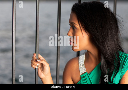 Giovane donna di fronte a una ringhiera, ritratto Foto Stock
