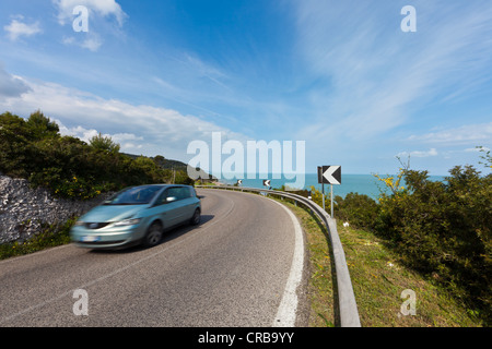 Strada vicino a Vico del Gargano con il passaggio di un auto, in provincia di Foggia, Puglia, Puglia, Gargano, Mare Adriatico, Italia, Europa Foto Stock