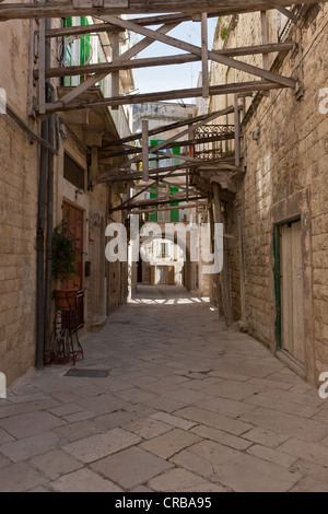 Vicolo del centro storico della città di Molfetta, le vecchie case sono supportati con travi in legno, Puglia Puglia, Italia Meridionale Foto Stock