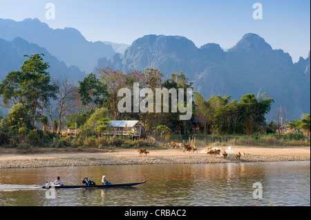 Mandria di bufali e canoa sul Nam Song River, montagne carsiche, Vang Vieng, Vientiane, Laos, Indocina, Asia Foto Stock