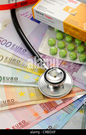 Pillole e uno stetoscopio su un fan delle banconote in euro, immagine simbolica del malato di euro, health care esplosione dei costi Foto Stock