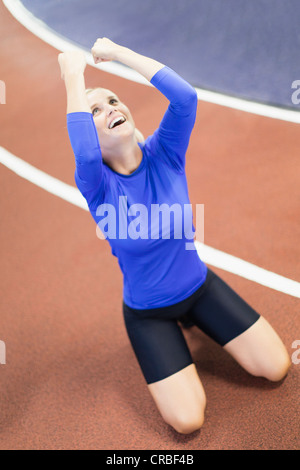 La donna grida sulla pista coperta in palestra Foto Stock