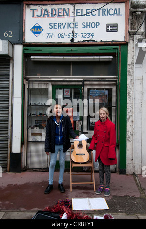 Hackney. Chatsworth Road. Le giovani ragazze cantando canzoni di Natale nel mercato Foto Stock