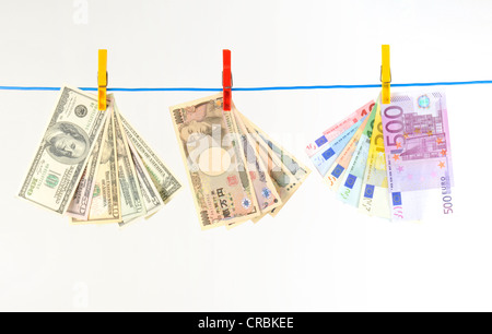 Euro, in dollari USA e yen giapponesi, note su uno stendibiancheria, immagine simbolica per il riciclaggio di denaro sporco denaro, tasso di cambio Foto Stock