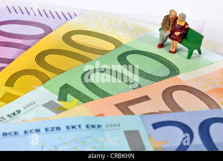 I pensionati figurine, una panchina nel parco su euro nota, immagine simbolica per la pensione, pensione Foto Stock