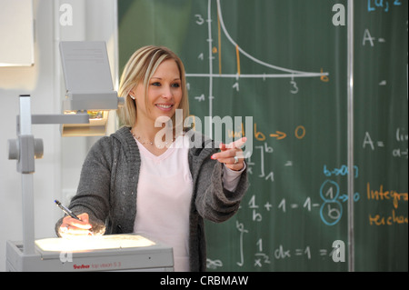 Tirocinante, insegnante di prospettiva, giovane insegnante, matematica, lavagna, classe, proiettore a soffitto, Baden-Wuerttemberg Foto Stock