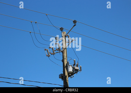 La linea di alimentazione in zona residenziale contro il cielo blu Foto Stock
