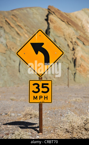 Segno di traffico, la curva in avanti e 35 km/h il limite massimo di velocità, il Parco Nazionale della Valle della Morte, Deserto Mojave, California Foto Stock