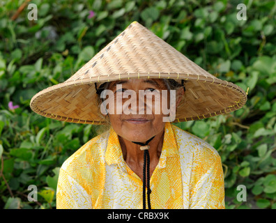 Donna indonesiana indossando un tradizionale cappello di paglia, Ubud, Bali, Indonesia, sud-est asiatico Foto Stock