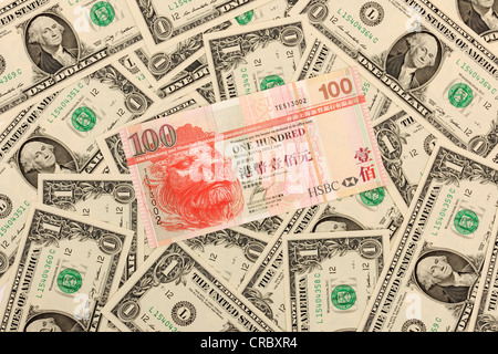 100 dollaro di Hong Kong banconota che giace al di sopra di 1 US Dollar Bills Foto Stock