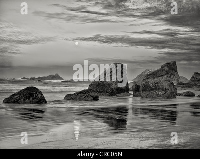 Sunrise e calare della luna piena con la riflessione a Harris Beach State Park, Oregon Foto Stock