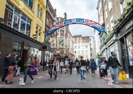 I segni e i negozi e gli amanti dello shopping a Carnaby Street London REGNO UNITO Foto Stock