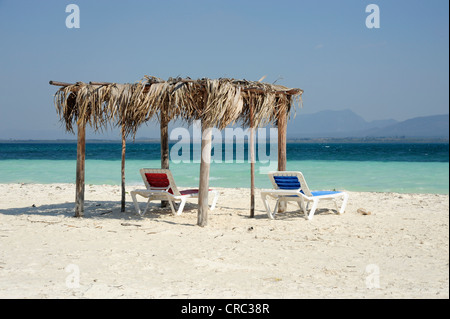 Due sedie a sdraio sotto un ombrellone sulla spiaggia, Cayo Levisa isola, Pinar del Rio provincia, Cuba, Greater Antilles Foto Stock