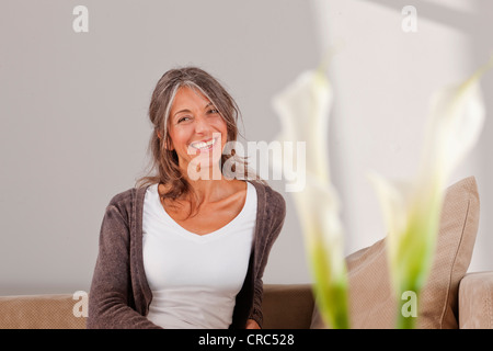 Donna anziana rilassante sul divano Foto Stock