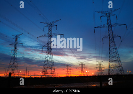 Le linee di alimentazione contro il cielo al tramonto Foto Stock