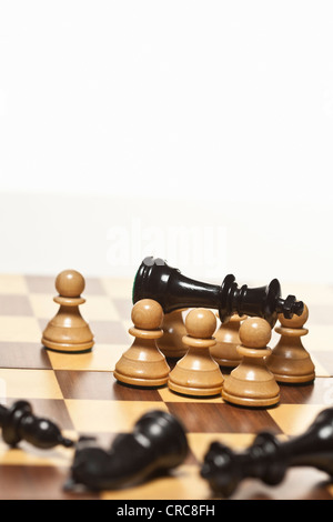 Pedine bianco nero circostante re di scacchi Foto Stock