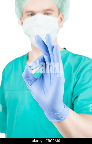 Chirurgo maschio mostra ok segno con le sue dita e isolato su bianco Foto Stock