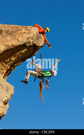 Il team di arrampicata di lotta per il vertice di un impegnativo rock mountain. Foto Stock