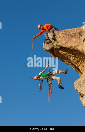 Il team di arrampicata di lotta per il vertice di un impegnativo rock mountain. Foto Stock