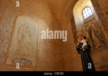 Affresco di San Antonio il Grande, o Antonio Abate, con una statua di Antonio di Padova, in una cappella laterale della gotica basilica di Foto Stock