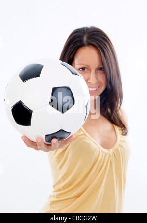 Giovane donna carina con pallone da calcio Foto Stock