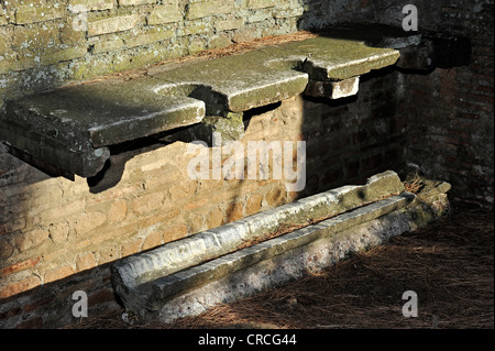 I sedili di gabinetto con un canale in una latrina pubblica, Ostia Antica sito archeologico, antico porto della città di Roma, lazio, Italy Foto Stock