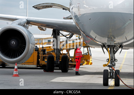 Personale di terra di lavorare sotto un Airbus Lufthansa all'aeroporto di Monaco di Baviera, Germania, Europa Foto Stock